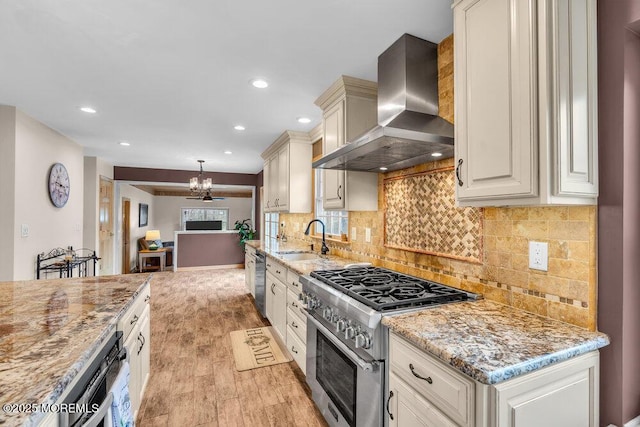 kitchen featuring a sink, light stone counters, light wood finished floors, stainless steel appliances, and extractor fan