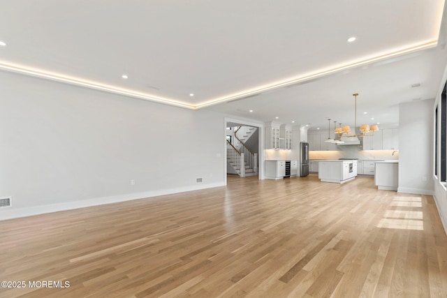 24 Baruch Dr, Long Branch, NJ 07740 - unfurnished living room with stairway, light wood finished floors, recessed lighting, and a chandelier