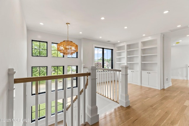 24 Baruch Dr, Long Branch, NJ 07740 - hall with an upstairs landing, recessed lighting, light wood-style flooring, a chandelier, and built in shelves