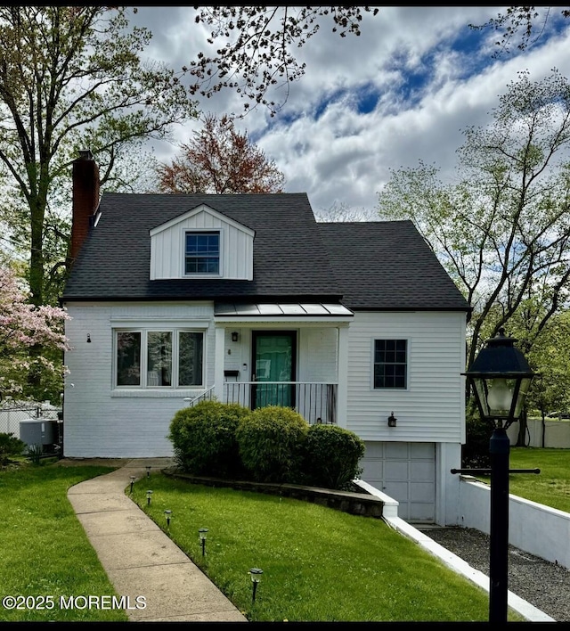 cape cod home featuring a front yard, central air condition unit, a chimney, brick siding, and an attached garage