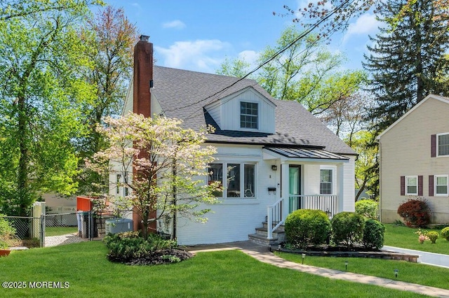 view of front of house with fence, a chimney, roof with shingles, and a front lawn