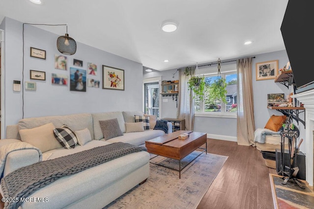 living area featuring baseboards, recessed lighting, wood finished floors, and a fireplace