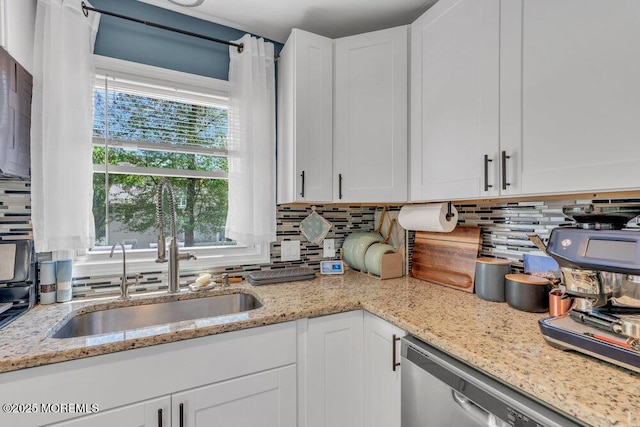 kitchen with white cabinetry, decorative backsplash, a sink, and dishwasher