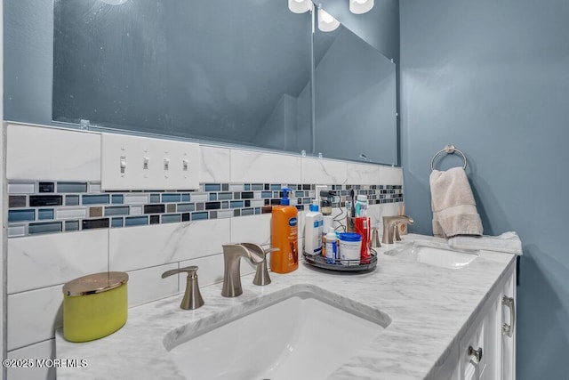 full bath with a sink, decorative backsplash, and double vanity