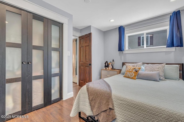 bedroom featuring recessed lighting, baseboards, wood finished floors, and a closet