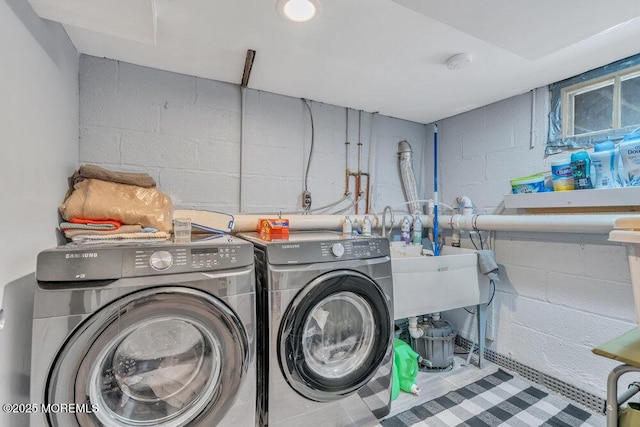 washroom with separate washer and dryer and concrete block wall
