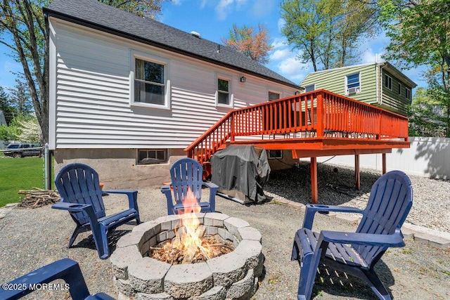 back of house featuring a deck and an outdoor fire pit