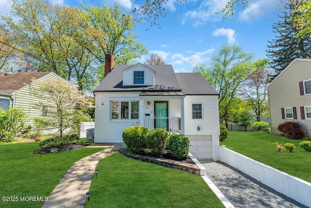 view of front of home featuring a front lawn, brick siding, a garage, a chimney, and driveway