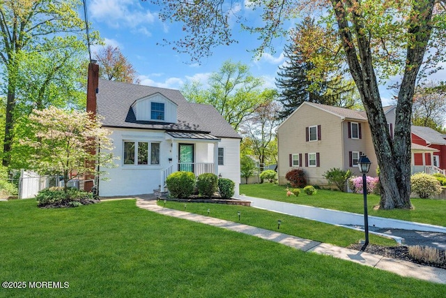 view of front of house featuring a chimney and a front lawn
