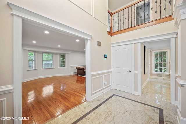 foyer with inlaid floor details, recessed lighting, baseboards, and wainscoting
