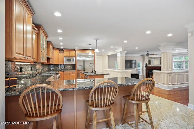 kitchen with built in appliances, a ceiling fan, tasteful backsplash, recessed lighting, and ornamental molding