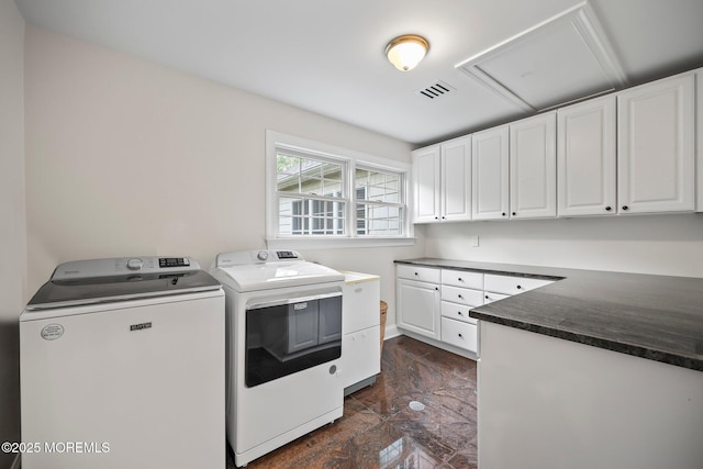 laundry area with separate washer and dryer and cabinet space
