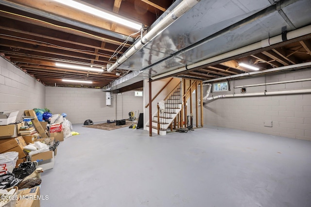 below grade area featuring stairs and concrete block wall