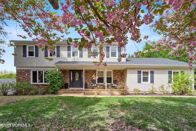 traditional-style home with a porch, a front lawn, and brick siding