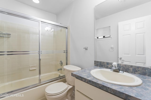 full bathroom with toilet, vanity, and bath / shower combo with glass door