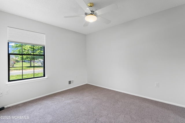 unfurnished room with baseboards, a ceiling fan, visible vents, and carpet