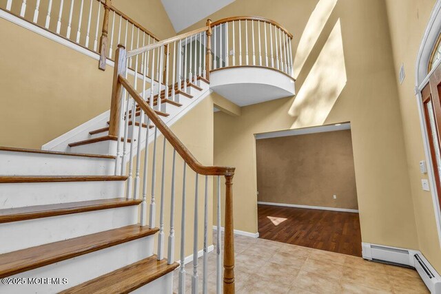 65 Pineoaka Rd, Jackson, NJ 08527 - stairway featuring high vaulted ceiling, a baseboard heating unit, and wood finished floors