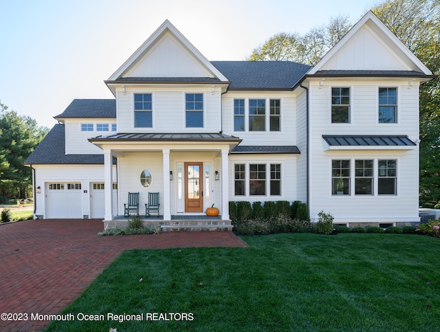 view of front of home with covered porch, decorative driveway, a standing seam roof, and board and batten siding