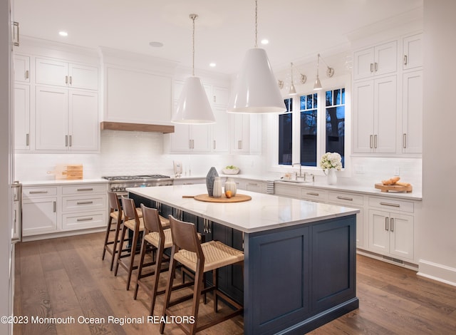 kitchen featuring a sink, a center island, white cabinets, and dark wood finished floors