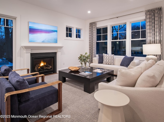 living area with carpet flooring, recessed lighting, and a fireplace with flush hearth