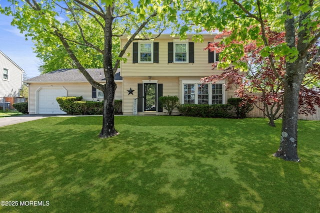 colonial house featuring concrete driveway, an attached garage, and a front yard
