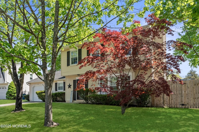 view of front of home with a garage, a front lawn, and fence