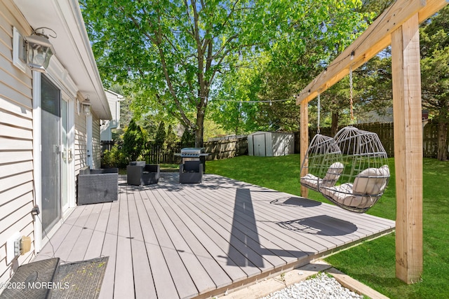 deck featuring area for grilling, an outbuilding, a shed, and a fenced backyard