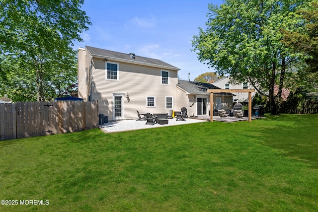 back of property with a yard, a fenced backyard, a patio area, and an outdoor fire pit