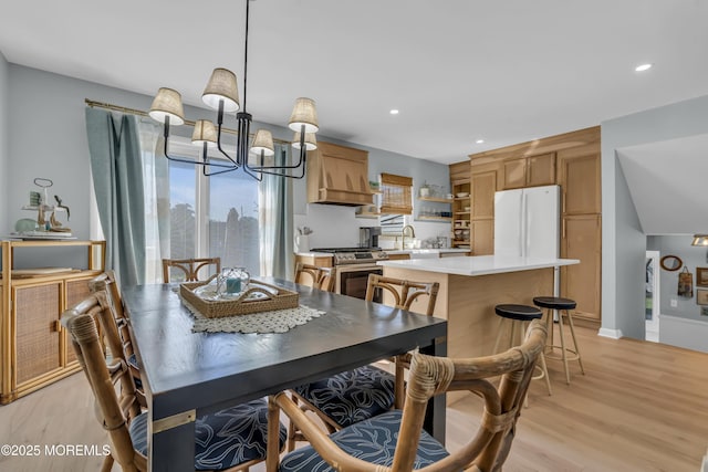 dining area with recessed lighting, light wood finished floors, baseboards, and a notable chandelier