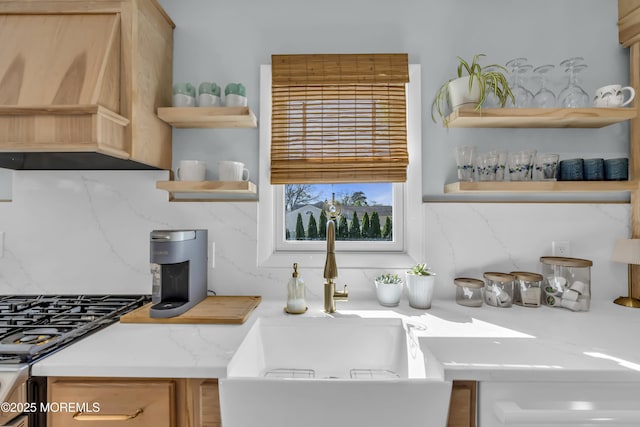 kitchen with backsplash, open shelves, a sink, and custom range hood