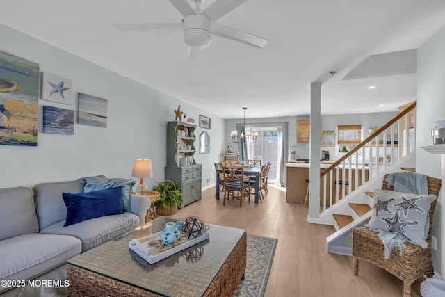 living area featuring ceiling fan, recessed lighting, baseboards, light wood-type flooring, and stairway