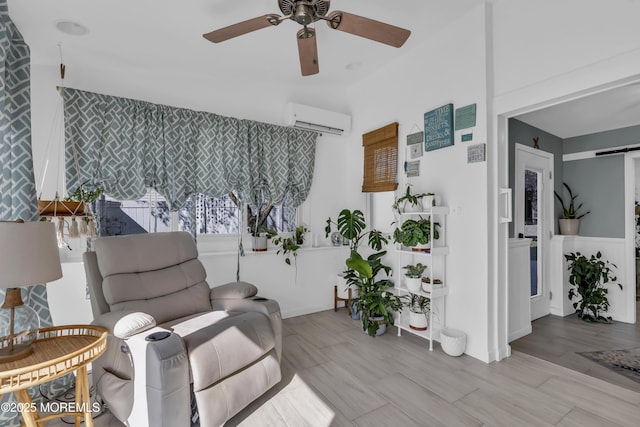 living area with a wall mounted air conditioner, a ceiling fan, wood finished floors, and a barn door