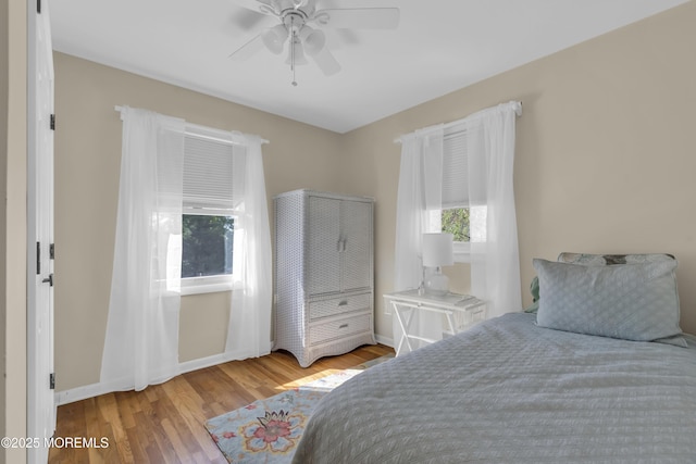 bedroom with baseboards, a ceiling fan, and wood finished floors