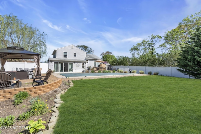 rear view of house featuring a patio area, a gazebo, a fenced in pool, a fenced backyard, and a yard