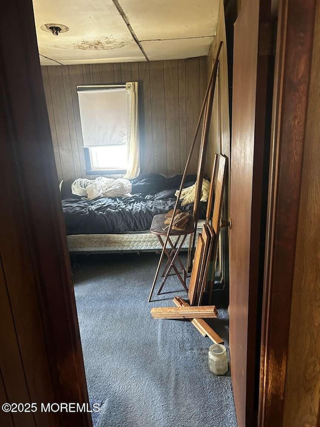 bedroom with wood walls and carpet flooring