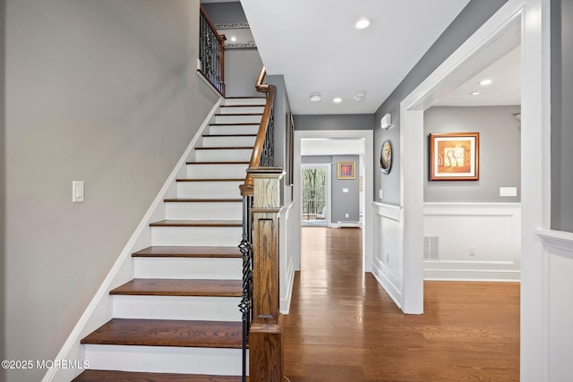stairs with a wainscoted wall, recessed lighting, wood finished floors, and visible vents