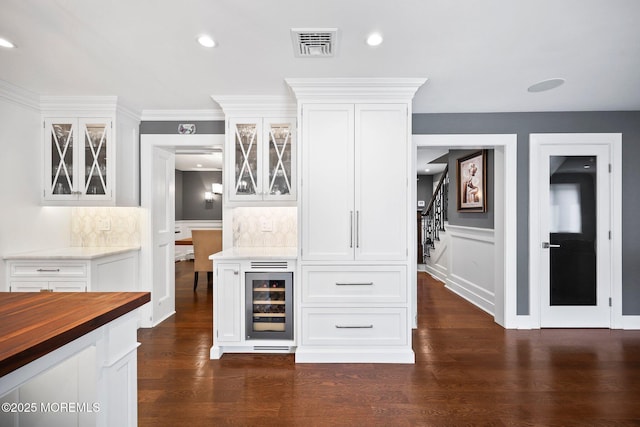bar featuring tasteful backsplash, wine cooler, visible vents, a bar, and stairway