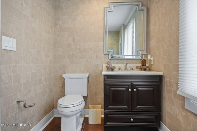 bathroom featuring tile walls, vanity, and toilet