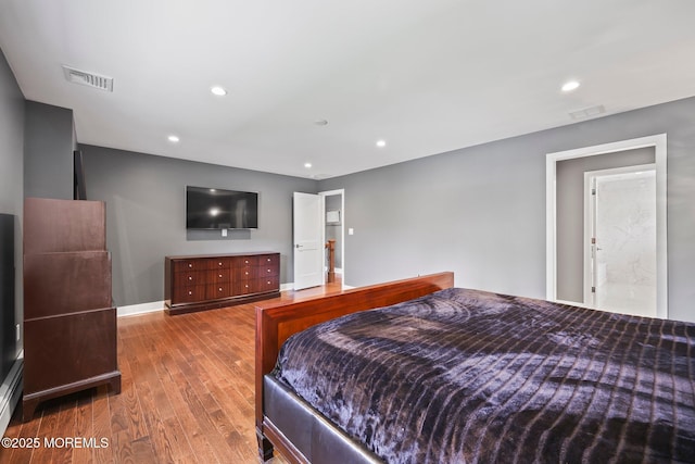bedroom with baseboards, recessed lighting, wood finished floors, and visible vents