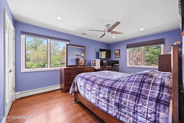 bedroom featuring visible vents, recessed lighting, wood finished floors, and baseboard heating