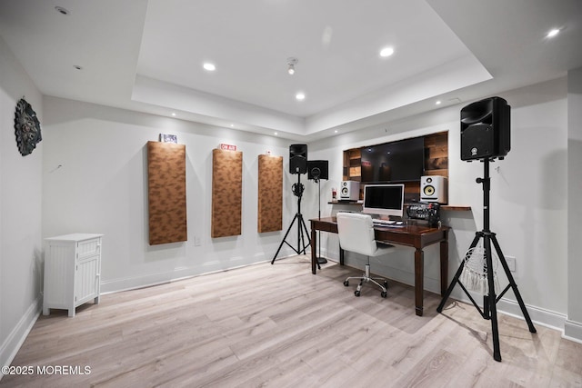 office with recessed lighting, baseboards, wood finished floors, and a raised ceiling