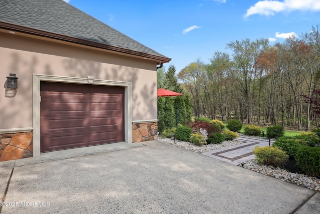 view of home's exterior with roof with shingles, stucco siding, driveway, and stone siding