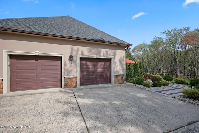 view of side of property with roof with shingles, stucco siding, stone siding, and concrete driveway