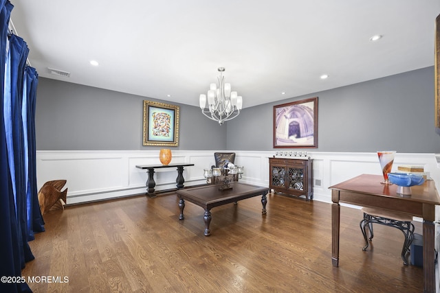 interior space with visible vents, wainscoting, wood finished floors, and a chandelier