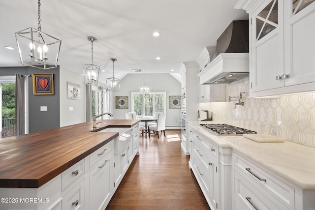 kitchen with tasteful backsplash, a sink, butcher block counters, a chandelier, and stainless steel gas stovetop