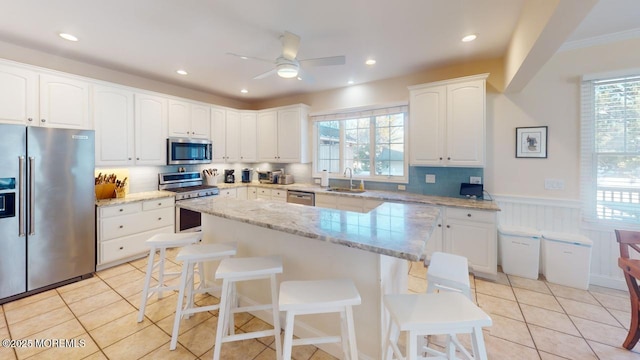 12 23rd Ave, South Seaside Park, NJ 08752 - kitchen with appliances with stainless steel finishes, light tile patterned floors, a sink, a breakfast bar area, and a kitchen island