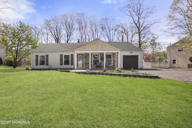 ranch-style home featuring fence, a front lawn, a garage, a porch, and driveway