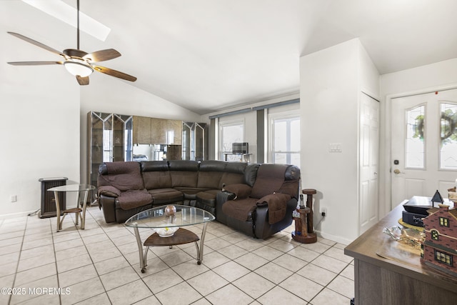 living room with baseboards, a ceiling fan, light tile patterned flooring, and lofted ceiling