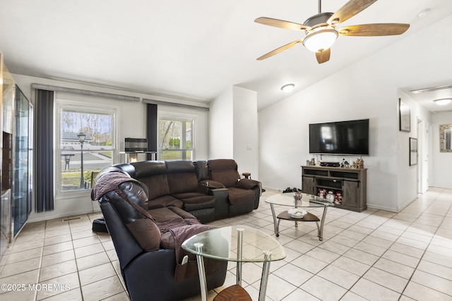 living area featuring baseboards, a ceiling fan, light tile patterned flooring, and lofted ceiling