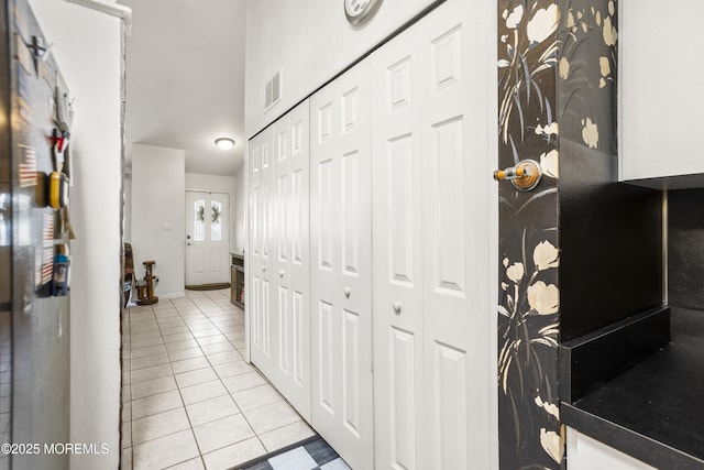 hallway with visible vents and light tile patterned floors